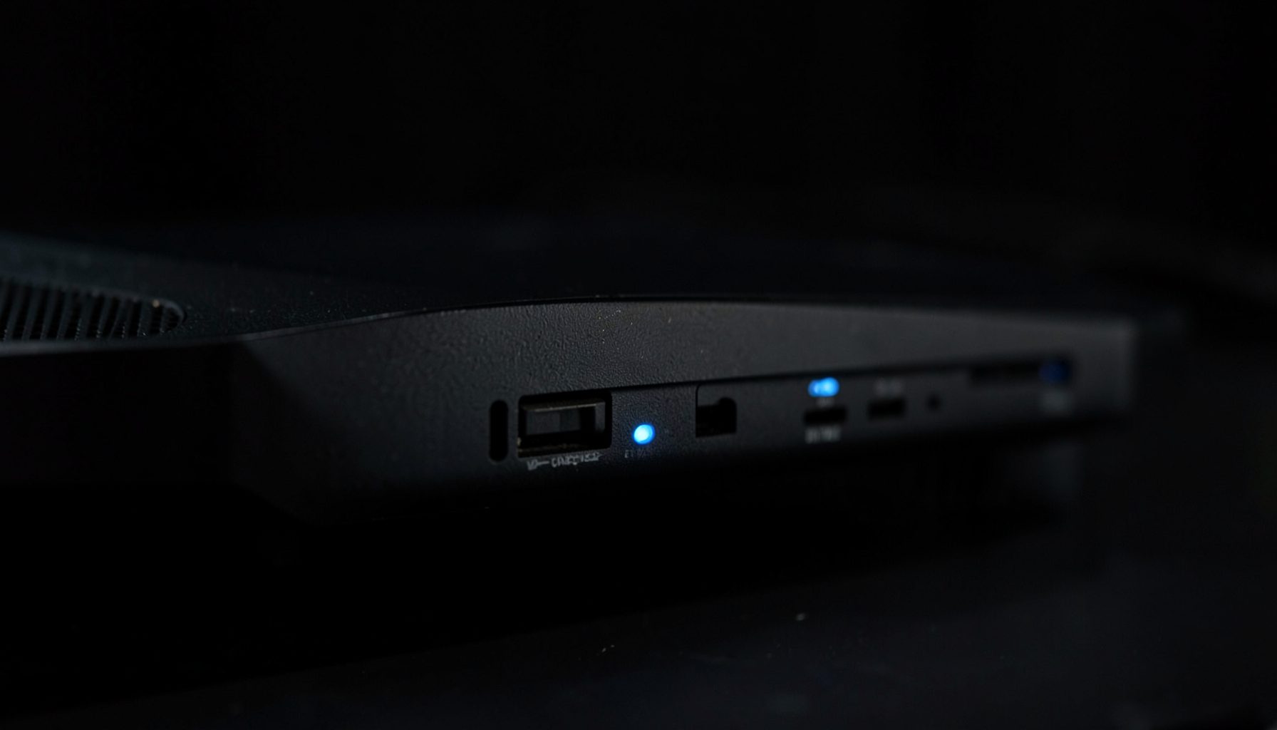 Close-up of sleek dark electronic equipment with subtle blue indicator lights against a shadowed background